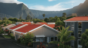 Maisons tropicales aux toits rouges devant montagnes verdoyantes