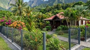 Maison tropicale entourée de jardin luxuriant et montagnes