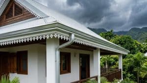 Maison tropicale avec véranda et montagnes nuageuses
